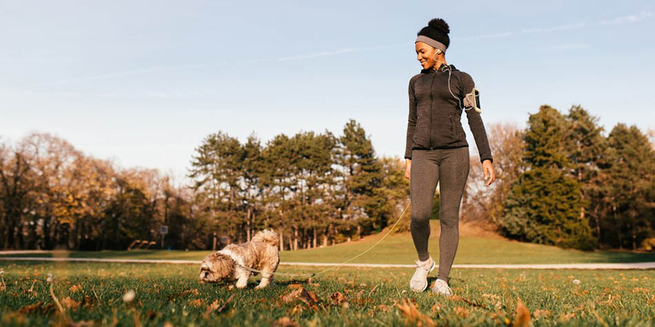 A woman walking with her dog.